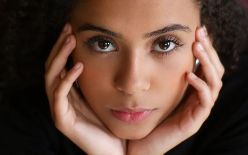 Woman touching her jaw in discomfort, a common sign of TMJ disorder