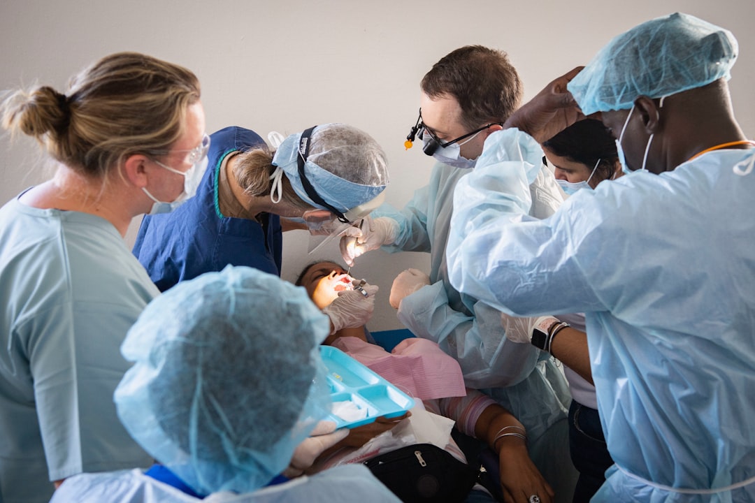 Medical professionals practice a dental procedure on a mannequin