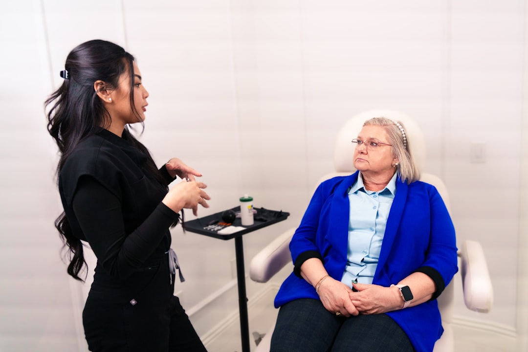 Professional consults with a seated client in a medical office