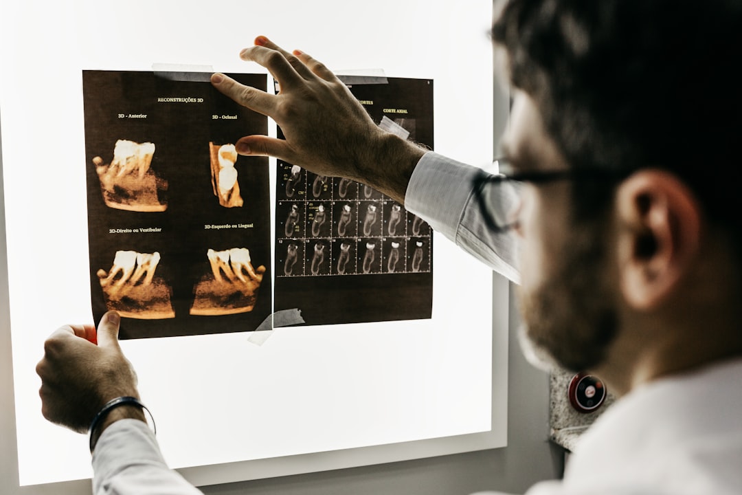 A dentist examining dental x-ray scans on a bright light box